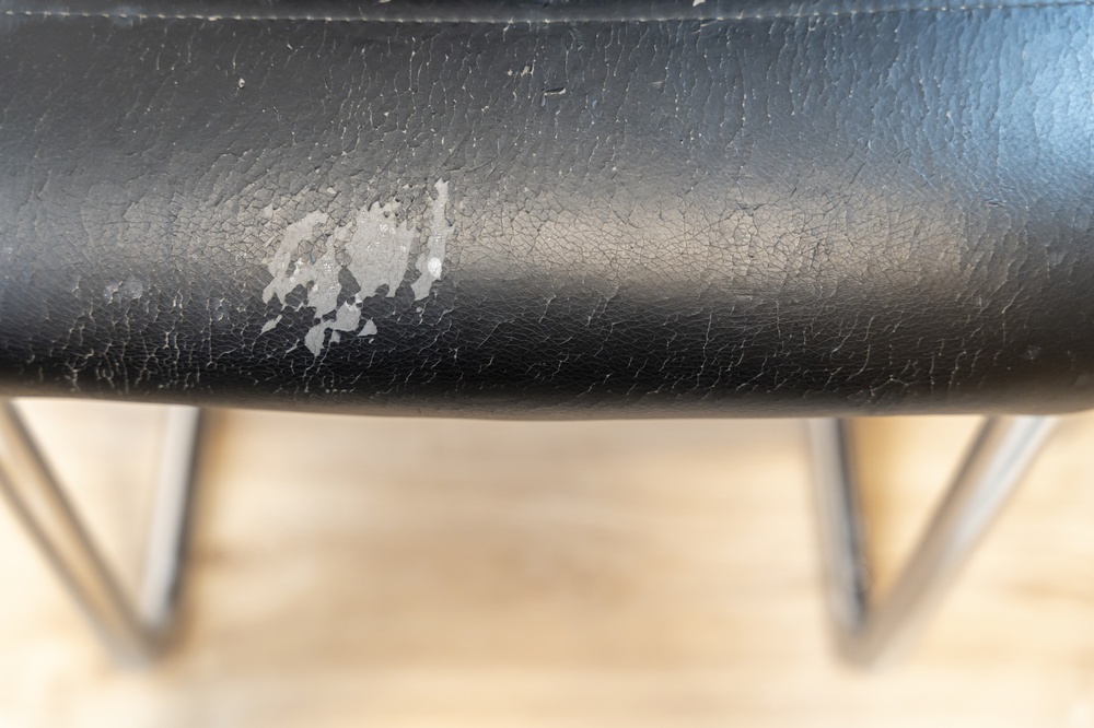 worn chair seat showing visible damage from repeated use
